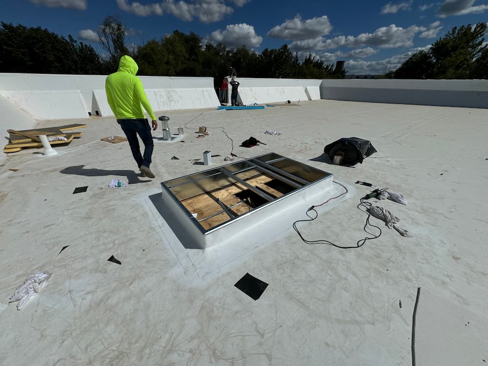 Roofing experts working on a large residential project under sunny conditions.