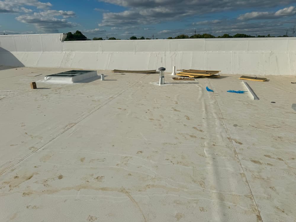 Roofing professionals working on a residential property under clear skies