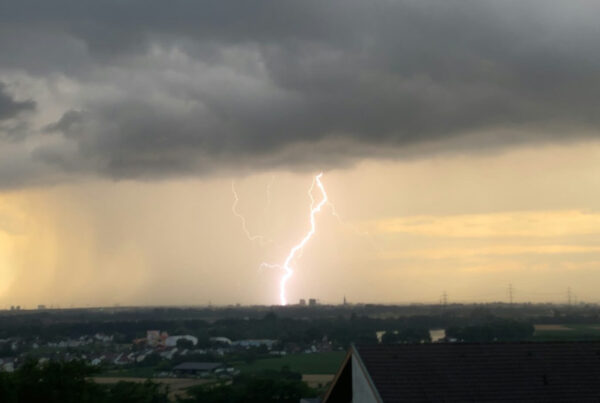 Stormy weather with rain falling on a roof, highlighting durability under harsh conditions.